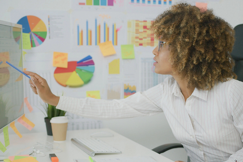 GHG Protocol - Image of person calculating emissions, surrounded by graphs